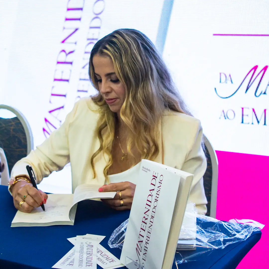 Coautora autografando um exemplar